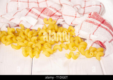 Menge ganze cavatappi Pasta mit einem Geschirrtuch auf weißem Holz Stockfoto