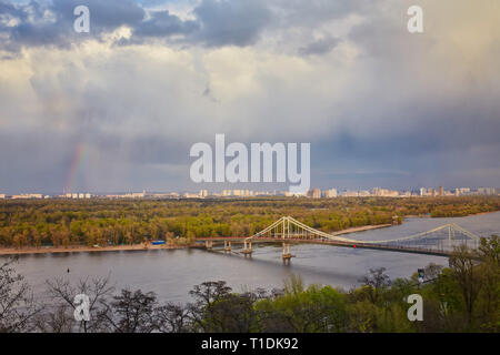 Blick auf die Fußgänger-Brücke und Regenbogen und dem Fluss Dnepr von oben, Kiew, Ukraine Stockfoto