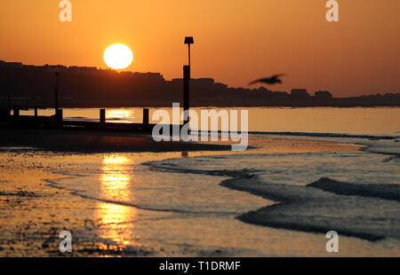 Die Sonne über Boscombe Strand in Dorset. Stockfoto