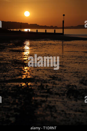 Die Sonne über Boscombe Strand in Dorset. Stockfoto