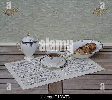 Englisch Teetasse mit Untertasse, Sugar Bowl und einem Kuchen Schüssel mit Cookies, Fine Bone China Porzellan, auf einem Blatt von Musik Stockfoto