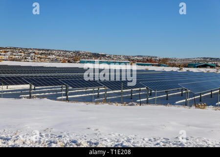 Solar Panels Solar Power Station im Schnee bedeckte Berge und weißen Wolken in der Grünen und umweltfreundlichen Energie. Stockfoto