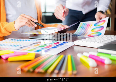 Grafik Design Partner zusammen arbeiten, Renovierung und Technologie Konzept - auf einem Desktop Computer und über einige Farbmuster Auswahl Stockfoto