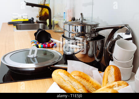 Sauber pan und vielen Töpfen auf die gelbe Küche aus Holz Tisch. Stockfoto