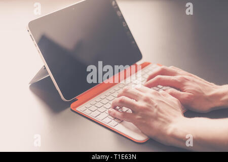 Männliche Hände und weiß orange Convertible Notebook Stockfoto