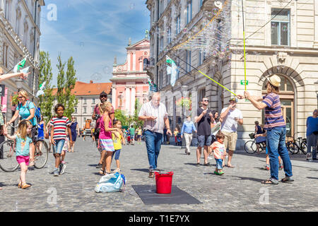 Urban Street artist Durchführen einer Soap Bubble Show für Kinder in der mittelalterlichen Innenstadt der slowenischen Hauptstadt Ljubljana Stockfoto