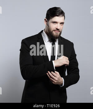 Ernsthafte Geschäftsmann sein Cuff Link auf der Hülle der Shirt Stockfoto