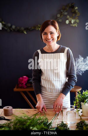 Junge kreative Frau in einem Blumenladen. Ein Anlauf von Blumengeschäft Geschäft. Stockfoto