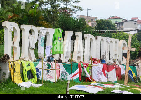 Brumadinho, Brasilien. 19 Mär, 2019. Vor dem großen Schriftzug "Brumadinho' kreuzt, T-shirts und Inschriften erinnern an die Opfer der Katastrophe. Am 25. Januar 2019, der Verdammung des Córrego tun Feijão Eisenerzbergwerk brach und eine tödliche Schlammlawine gestartet. Zwei Monate später, Wut, Trauer und Verzweiflung herrschen. (Dpa "Alles ist Weg"-Bewohner von Brumadinho leiden unter perineale Tragödie') Credit: Rodney Costa/dpa/Alamy leben Nachrichten Stockfoto