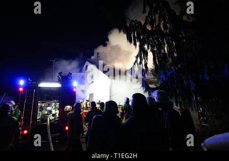 Hochdorf Unteressendorf, Deutschland. 26 Mär, 2019. Feuerwehrmänner der Feuerwehr sind bei dem Brand eines Einfamilienhauses. Nachdem der Brand gelöscht war, zwei Körper waren im Gebäude entdeckt. Foto: Thomas Warnack/dpa/Alamy leben Nachrichten Stockfoto