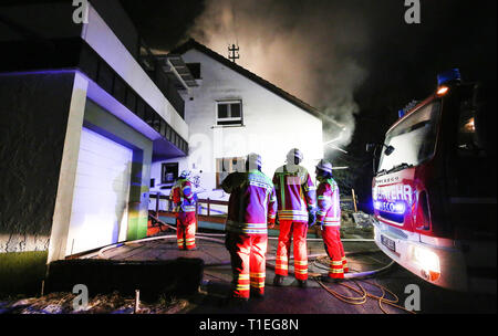 Hochdorf Unteressendorf, Deutschland. 26 Mär, 2019. Feuerwehrmänner der Feuerwehr sind bei dem Brand eines Einfamilienhauses. Nachdem der Brand gelöscht war, zwei Körper waren im Gebäude entdeckt. Foto: Thomas Warnack/dpa/Alamy leben Nachrichten Stockfoto