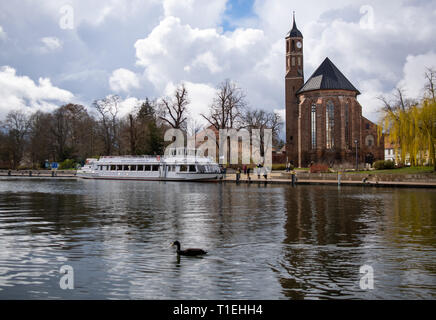 Brandenburg an der Havel, Deutschland. 25 Mär, 2019. Ein Ausflug Schiff liegt am Salzufer. Auf der rechten Seite die Johanniskirche (St. John's Church) vor die Himmel gesehen werden. Das ehemalige Franziskanerkloster Kirche wurde im gotischen Stil erbaut und ist zurzeit als Veranstaltungssaal genutzt. Credit: Monika Skolimowska/dpa-Zentralbild/dpa/Alamy leben Nachrichten Stockfoto