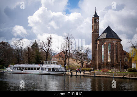 Brandenburg an der Havel, Deutschland. 25 Mär, 2019. Ein Ausflug Schiff liegt am Salzufer. Auf der rechten Seite die Johanniskirche (St. John's Church) vor die Himmel gesehen werden. Das ehemalige Franziskanerkloster Kirche wurde im gotischen Stil erbaut und ist zurzeit als Veranstaltungssaal genutzt. Credit: Monika Skolimowska/dpa-Zentralbild/dpa/Alamy leben Nachrichten Stockfoto