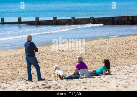 Bournemouth, Dorset, Großbritannien. 26 Mär, 2019. UK Wetter: einen anderen netten warmen sonnigen Tag mit blauen Himmel und warmen Sonnenschein am Bournemouth Strände, als Besucher an der Küste die herrlichen Wetter zu machen. Reifen Mann, der zwei Frauen sitzen auf dem Sand zu plaudern. Credit: Carolyn Jenkins/Alamy leben Nachrichten Stockfoto