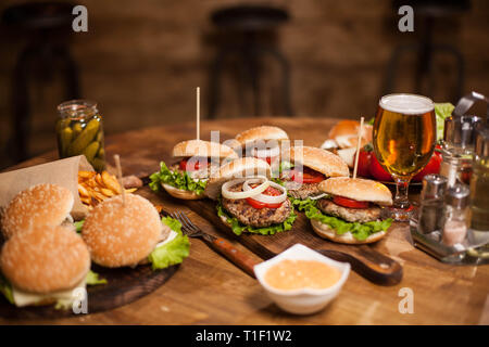 Viele leckere Burger liegen auf einem Tisch in einem alten Pub oder Restaurant Stockfoto