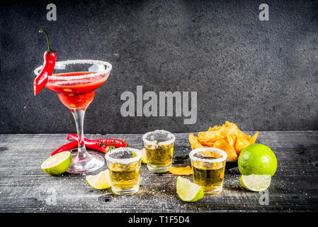Cinco de Mayo feier Konzept. Getränke 5. Mai mexikanischen Partei - Margarita Cocktail, tequila Schüsse mit Kalk, hot chili peppers und Chips, dunkle Bac Stockfoto