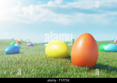 Bunte eier auf einer Wiese an einem sonnigen Tag gegen den blauen Himmel. Bunt bemalte Ostereier im Gras, Rasen. Konzept Ostereier Jagd in Sonntag. Ea Stockfoto