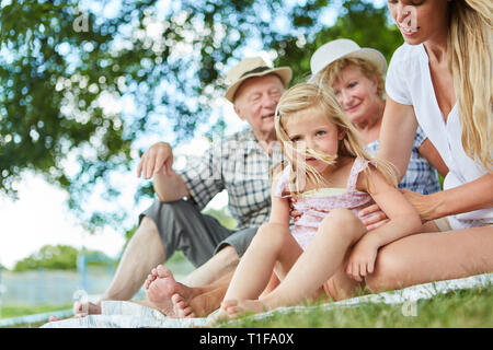 Erweiterte Familie im Garten oder auf einer Reise mit Kind und Großeltern im Sommer Stockfoto