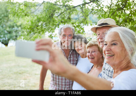 Ältere Frau mit Smartphone macht einen selfie Ihrer älteren Freunde im Urlaub Stockfoto
