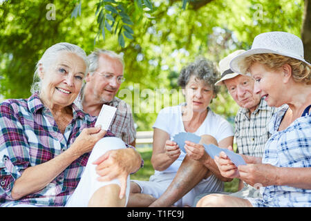 Gruppe der pensionierte ältere Freunde Karten spielen im Park im Sommer Stockfoto