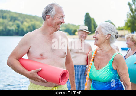 Gerne älteres Paar als lebenswichtige Rentner mit Freunden im Urlaub an der See im Sommer Stockfoto