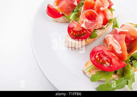 Jamon. Scheiben Brot mit Spanischer Serrano Schinken diente als Tapas. Schinken, spanische Vorspeise. Prosciutto isoliert auf weißem Hintergrund Stockfoto