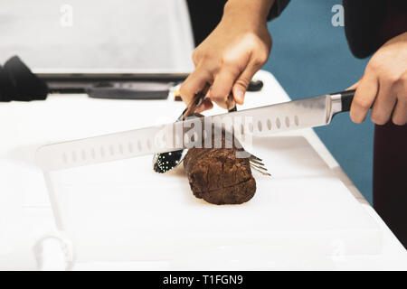 Roastbeef und Slice, Hände Chef's schneiden Roastbeef, Carving Roastbeef Stockfoto