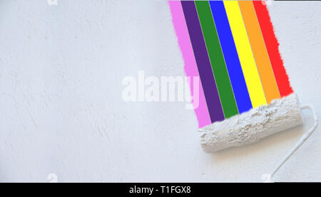 Malerei die Farben des Regenbogens auf einer weißen Wand mit Rolle eines Malers Stockfoto