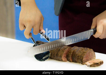 Roastbeef und Slice, Hände Chef's schneiden Roastbeef, Carving Roastbeef Stockfoto