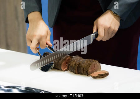 Roastbeef und Slice, Hände Chef's schneiden Roastbeef, Carving Roastbeef Stockfoto