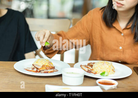 Weibliche Hand zusammendrücken Kalk auf gebratener Reis zum Mittagessen. Stockfoto