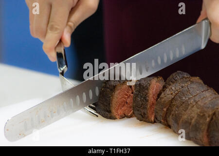 Roastbeef und Slice, Hände Chef's schneiden Roastbeef, Carving Roastbeef Stockfoto