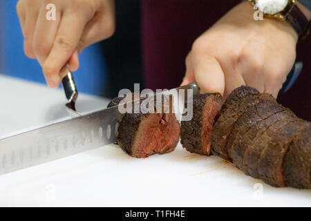 Roastbeef und Slice, Hände Chef's schneiden Roastbeef, Carving Roastbeef Stockfoto