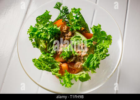 Salat mit Fleisch, Huhn, Salat, Dill, Tomaten auf weißem Holz Hintergrund. Für das Menü Restaurant Bar Cafe Stockfoto