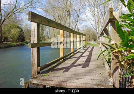 Ein Holzsteg über einen Deich vom Fluss Bure auf einem öffentlichen Fußweg an Coltishall, Norfolk, England, Vereinigtes Königreich, Europa. Stockfoto