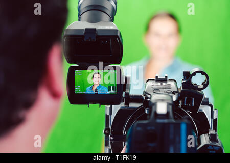 Kamera bei einer Nachrichten Frau oder Reporter in grüne Zimmer Studio Stockfoto