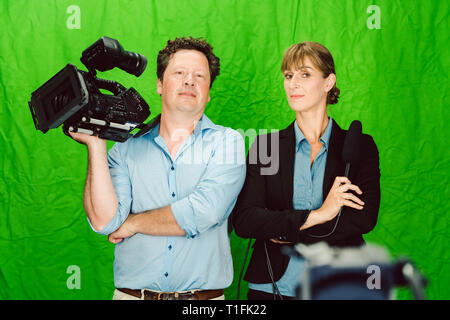 Crew der Reporter und Kameramann posiert im Studio Stockfoto