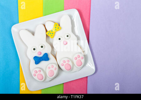 Osterhase Sugar Cookies auf eine quadratische Platte mit Servietten unter. Marshmallow Fondant überzogen Cookie mit Süßigkeiten Füße, Augen und Nase und Heck und b Stockfoto