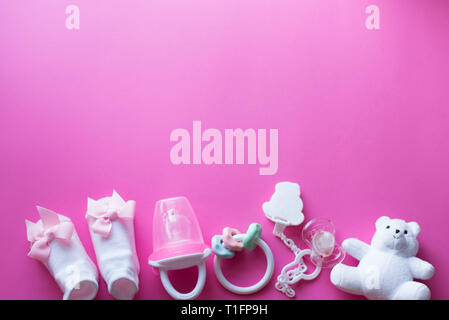 Baby Accessoires und Spielzeug auf rosa Hintergrund. Ansicht von oben. Kind flach mit weißen Spielzeug Stockfoto