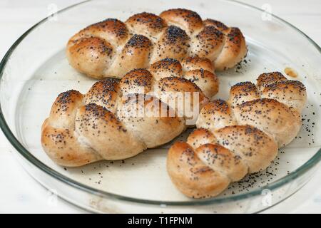 Rustikale hausgemachte Speisen. Drei Mohn bestreut glutenfreie Brötchen in Glas Fach frisch aus dem Ofen. Vegetarisches Essen, Bäckerei, rustikales Essen conc Stockfoto