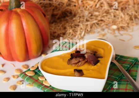 Sahne Kürbissuppe in Weiß in Herzform Schüssel in ländlichen Ländereinstellung Stockfoto