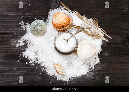 Still-Leben mit Salz, Muscheln und grobkörniges Meersalz auf Dunkelbraun Holzbrett Stockfoto