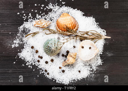 Blick von oben auf die Schalen und grobkörniges Salz und Pfeffer auf Dunkelbraun Holzbrett Stockfoto