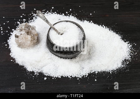 Vintage silver Salz mit Löffel, rauhe natürliche Halit Mineral- und feinkörnigen Steinsalz auf Dunkelbraun Holzbrett Stockfoto