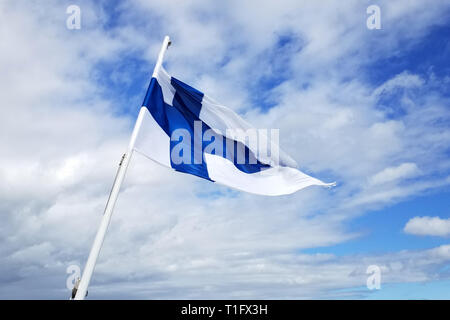 Weiße Flagge mit dem blauen Kreuz auf blauem Himmel Hintergrund Stockfoto