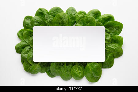 Rahmen aus spinatblättern auf weißem Hintergrund. Kreative essen Konzept. Zutat für Salate. Flach, Ansicht von oben Stockfoto