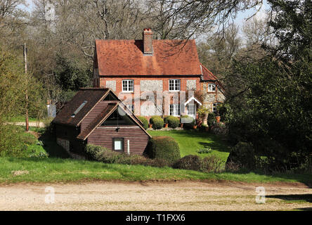 Ein traditionelles englisches Dorf Backstein und Feuerstein Haus und Garten im Frühjahr Stockfoto