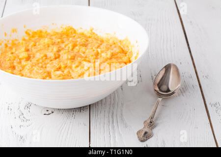 Prozess der Vorbereitung von Muffins. Kürbis zum Teig hinzufügen Stockfoto