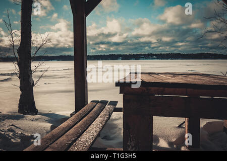 Arbeitsplatte mit Blick auf den Winter Lake. Winter Pavillon am Ufer eines zugefrorenen See. Stockfoto