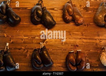 Foto von mehreren Boxhandschuhe hängen an der Wand Stockfoto